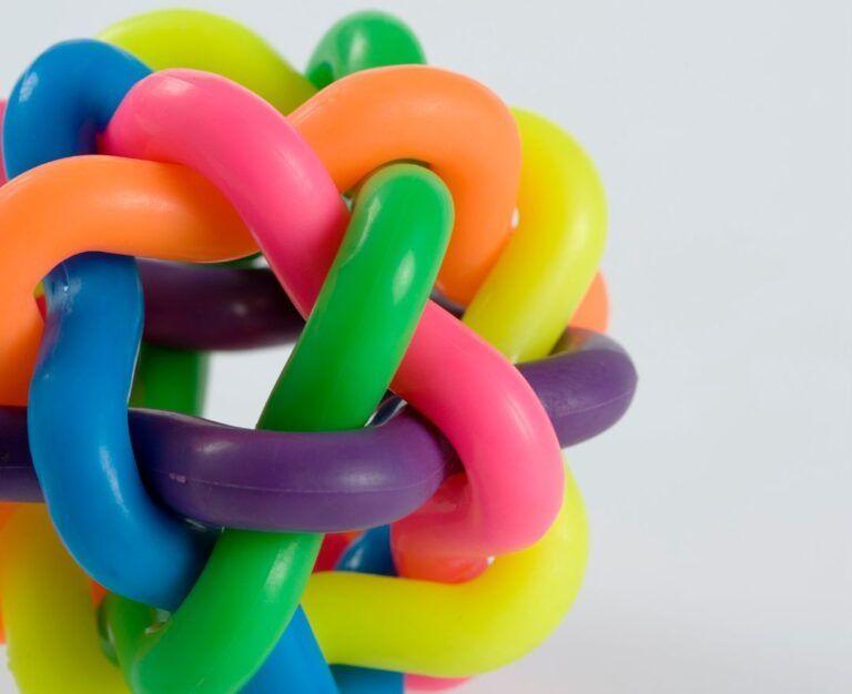 Банер для блогу до статті про синдром подразненого кишківника: сплутані між собою у клубок різнокольорові пластикові трубки на сірому фоні